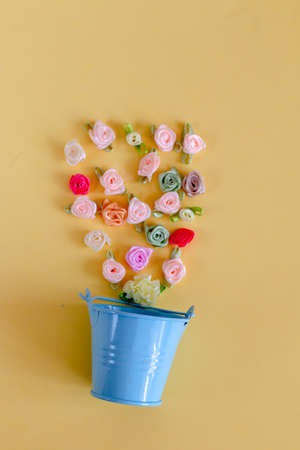 Frame of fabric textile silk flowers on a yellow background for handicraftの写真素材