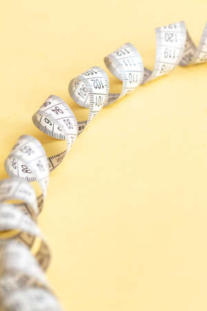 Tape-measure isolated on yellow,