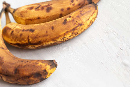 spoiled tainted bananas on gray background. Ugly food trendy photo. Food waste, food garbageの写真素材
