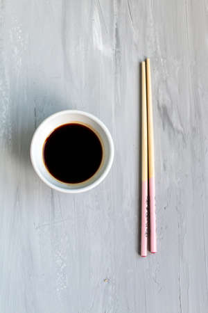 Traditional asian cutlery with plate, bowl for soy sauce bamboo sticks. Concept. With space for textの写真素材