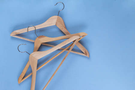 Wooden hanger on a blue background with space for textの写真素材