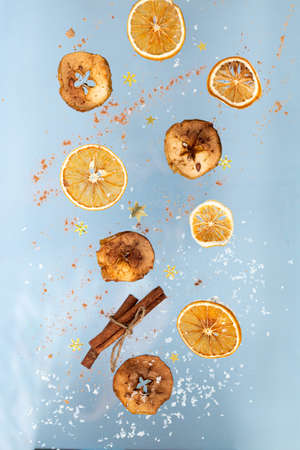 Flying orange and apple slices with a cinnamon sticks with snow and crumbles, template for Christmas...