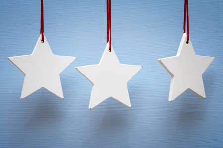 White wooden stars with red string, blue background, postcard templateの写真素材