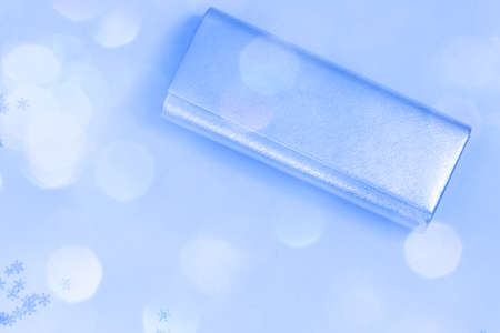 Clutch bag isolated on blue, soft selective focus, blurred bokeh background
