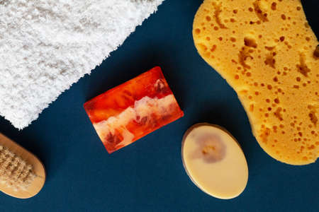 Bath accessories, handmade soap and white towel on blue background. Aromatherapy organic concept