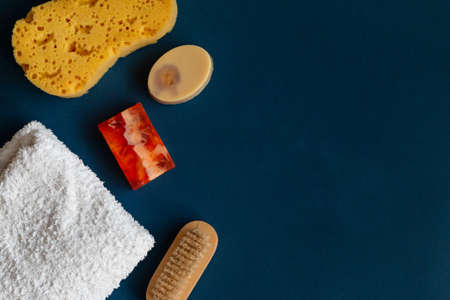 Bath accessories, handmade soap and white towel on blue background. Aromatherapy organic concept