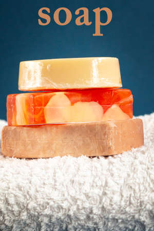 Bath accessories, handmade soap and white towel on blue background. Aromatherapy organic conceptの写真素材