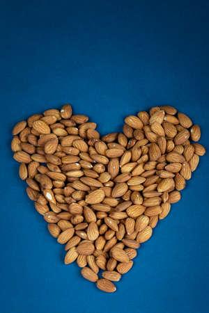 Almond seeds texture top view on blue color background, empty space for text, organic healthy food...