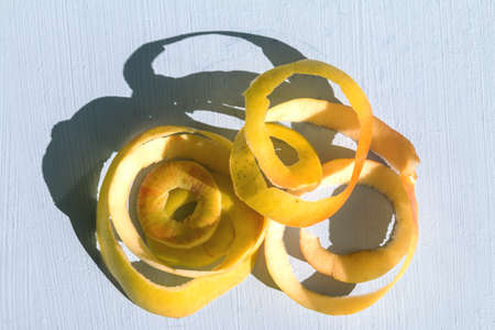 yellow apple with a hard sunlight and deep shadow on a table, zero waste still life and healthy food concept, empty space for textの写真素材