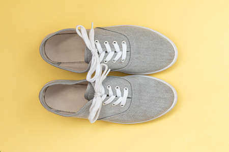 gray classic sneakers on yellow background