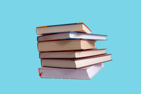 stack of books isolated on light blue background. Minimalism concept.
