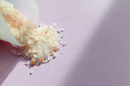 Pink sea salt crystals on purple background, natural light, space for textの写真素材