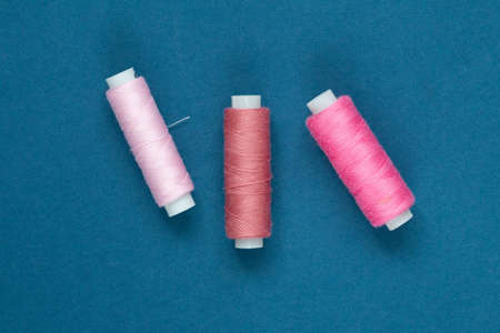 pink sewing needles against blue background, top viewの写真素材
