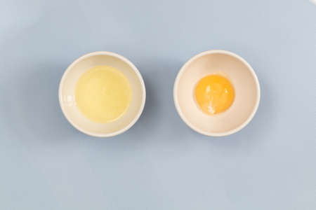 egg yolk in a bowl on blue background