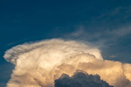 fluffy stormy clouds in the sunset skyの写真素材