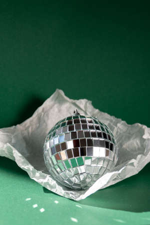 Disco ball in torn paper against emerald greenの写真素材