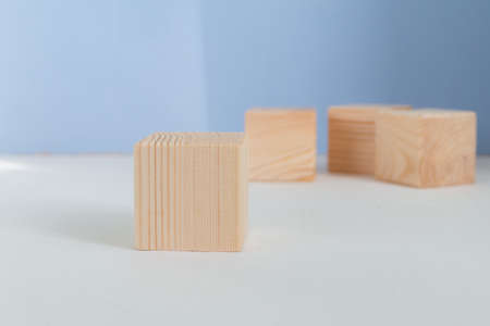 Empty wooden cubes against light blue background, showcase templateの写真素材
