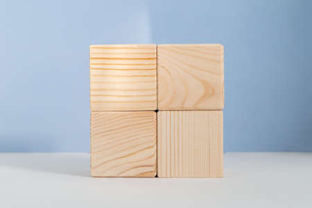 Empty wooden cubes against light blue background, showcase template