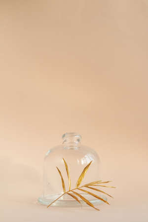 Golden palm leaf with glass jar on pink backgroundの写真素材