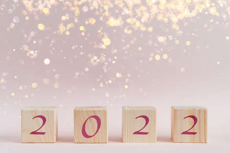 Wooden cubes pyramid with new year numbers and shining sparkles bokehの写真素材