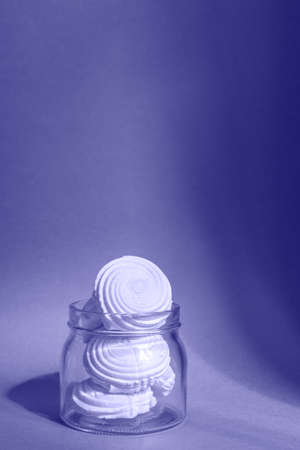 Homemade marshmallows in a paper cup isolated on purple backgroundの写真素材