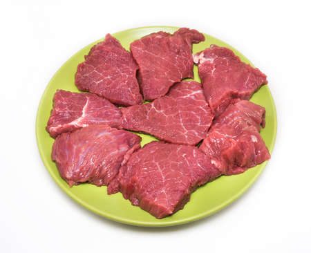 Appetizing pieces of beef on green plate on white background.の写真素材