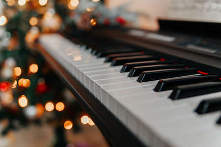 Piano keyboard with bright christmas lights on the background.の写真素材