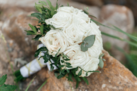 Bride's bouquet of white roses on a stone surface close-upの写真素材