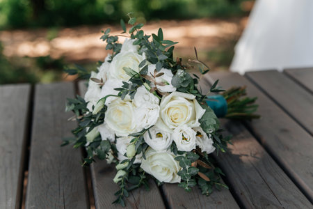 Bride's bouquet of white roses on a wooden surface close-upの写真素材
