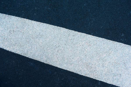 Blue and white grainy texture. Road surface. White strip on a blue backgroundの写真素材