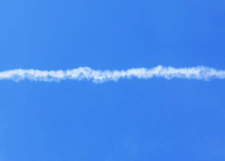 saturated blue sky with a white stripe from the plane