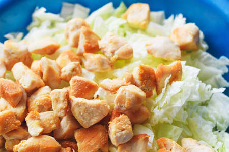 Chicken pieces and cabbage leaves. Salad ingredients. Cooking caesar salad.の写真素材