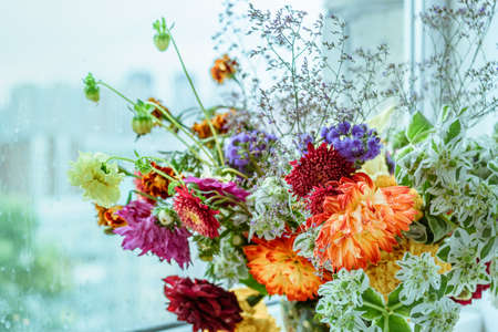 Autumn bouquet of different flowers. On the table, by the window. Autumn timeの写真素材