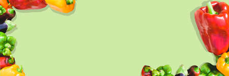 Banner with red, yellow and green peppers. Vegetables on a green background. Autumn harvest. Copy space.の写真素材