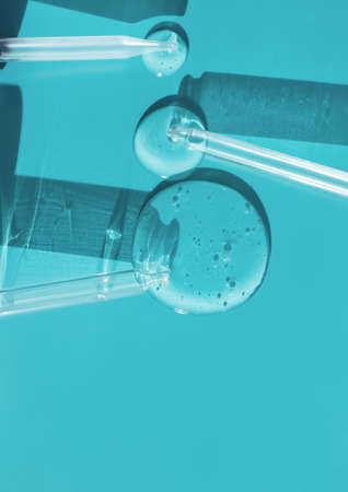 pipette drop of serum test on a blue backgroundの写真素材