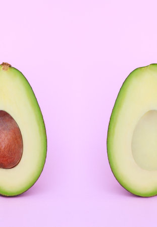 set of avocado cut in half on a pink backgroundの写真素材