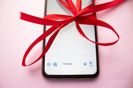 gift in red ribbon gadget, gift in a red ribbon gadget,the concept of Valentine's dayの写真素材