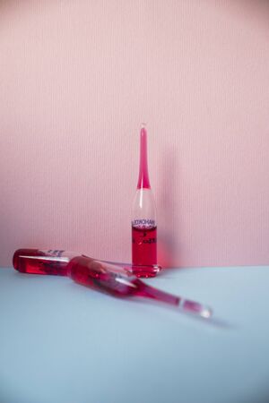 medical ampoules with red virus vaccine on a classic blue background