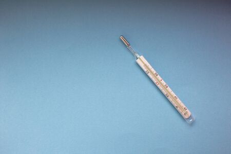 mercury thermometer on a blue background, top view