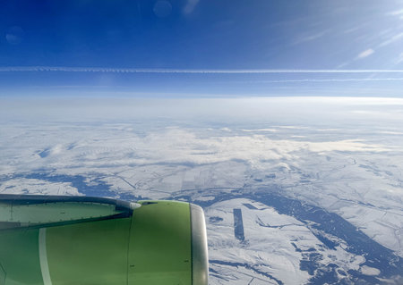 View of winter snow covered land from an airplane window.