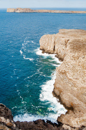 Stone cliffs on the coast of the blue sea. Raging water, waves, view from above. Gramvousa, Crete island, Greece.の写真素材