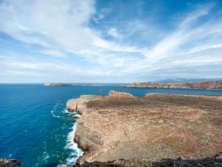 Stone cliffs on the coast of the blue sea. Raging water, waves, view from above. Gramvousa, Crete island, Greece.の写真素材