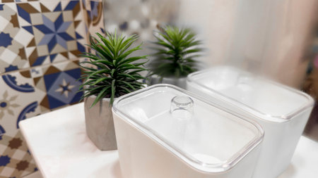 Minimalist Bathroom Decor with Concrete Planter and Patterned Ceramic Tiles. A stylish and modern setup featuring a green plant in a concrete pot alongside intricate geometric tile patterns.の写真素材