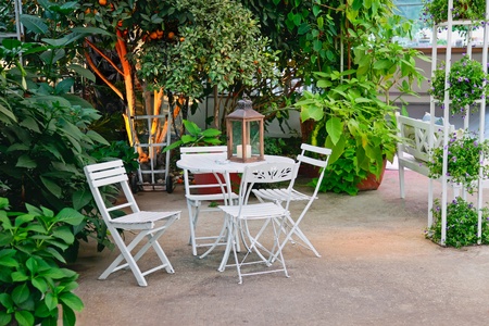 White table and chairs in beautiful garden の写真素材