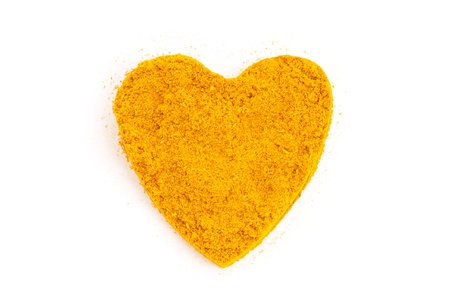 Heap ground Curry  Madras Curry  isolated in heart shape on white backgroundの写真素材