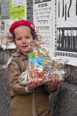 JERUSALEM, ISRAEL - MARCH 15, 2006: Purim carnival in the famous ultra-orthodox quarter of Jerusalem - Mea Shearim. Portrait of a boy children dressed in carnival costumes soldier. In his hand mishloach manot. Purim is celebrated annually according to theのeditorial素材