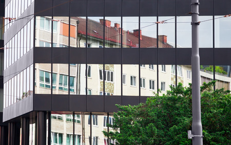 Old building architecture reflected in modern building. Front view of the building. Munich, Germany.