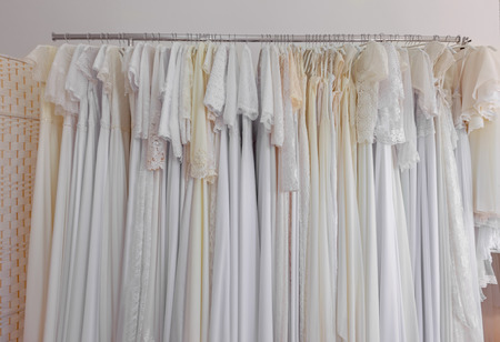 Beautiful bridal dress on a hangers. Wedding dresses in bridal salon.の写真素材