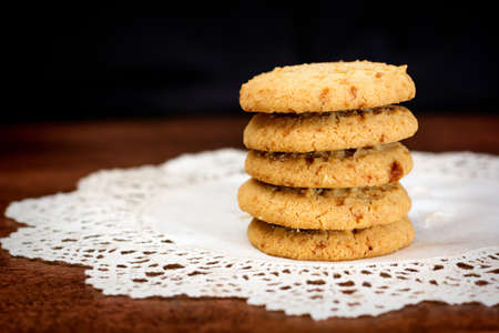 Close up of stacked apple chip cookies on white rustic napkin with wooden background