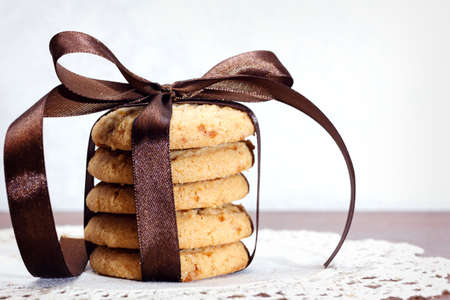 Close up of stacked apple chip cookies taped with silk ribbon on white rustic napkin